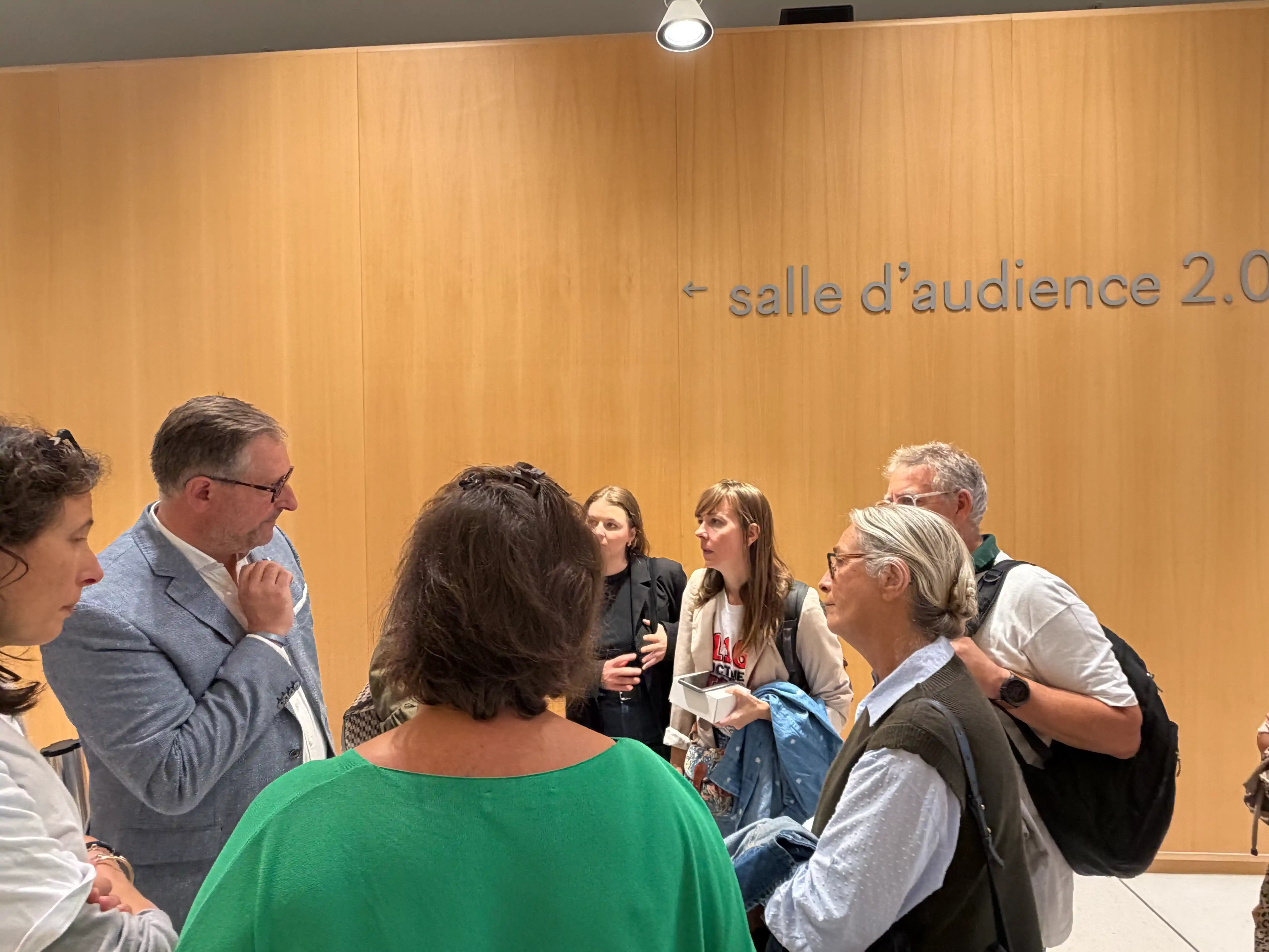 Grupo conversando cerca de la sala de audiencias · Sentencia Swiftair, vuelo Air Algérie AH5017, 28 de septiembre de 2026. Grupo conversando cerca de la sala de audiencias